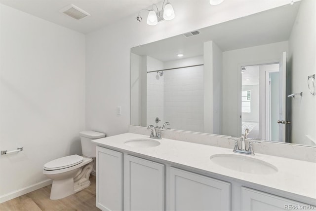 449 S Salida St, Aurora, CO 80017 - full bath with toilet, wood finished floors, double vanity, tiled shower, and baseboards