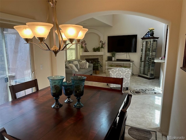 15501 E 112th Ave Unit 28E, Commerce City, CO 80022 - dining space with a chandelier, arched walkways, and a fireplace
