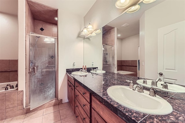 15501 E 112th Ave Unit 28E, Commerce City, CO 80022 - bathroom featuring double vanity, a bath, a shower stall, and tile patterned flooring