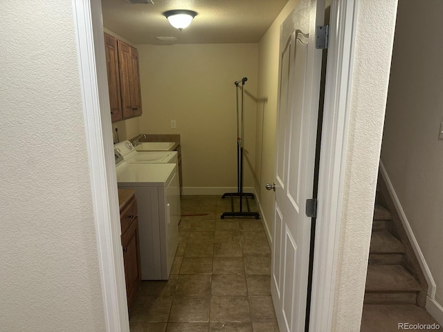 15501 E 112th Ave Unit 28E, Commerce City, CO 80022 - laundry room with washing machine and clothes dryer, cabinet space, dark tile patterned floors, and baseboards