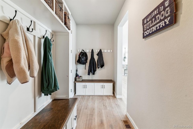mudroom featuring baseboards, visible vents, and light wood-style flooring