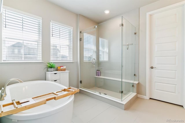 full bathroom with recessed lighting, a shower stall, and a soaking tub