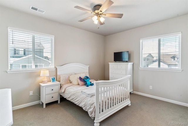 bedroom featuring carpet floors, visible vents, and multiple windows