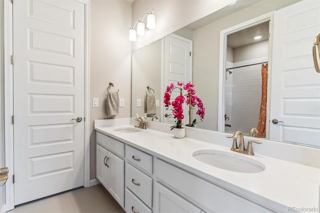 bathroom with a sink, a shower with curtain, tile patterned flooring, and double vanity