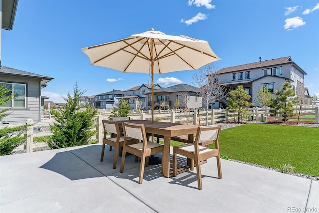 view of patio with outdoor dining area, fence, and a residential view