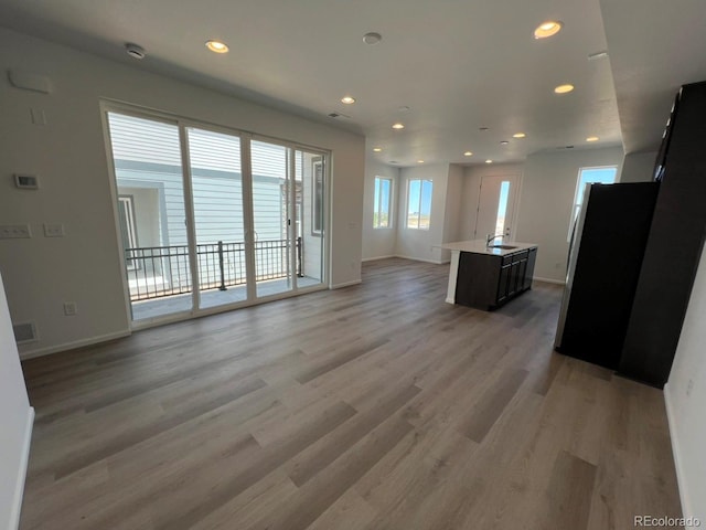 6599 N Netherland St, Aurora, CO 80019 - unfurnished living room with light wood-style floors and recessed lighting