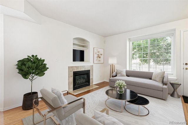 living room featuring a tile fireplace and hardwood / wood-style floors