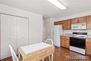 kitchen featuring dark hardwood / wood-style floors and white appliances