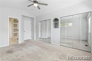 unfurnished bedroom with carpet flooring, ensuite bath, two closets, ceiling fan, and lofted ceiling