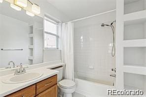 full bathroom featuring shower / bath combination with curtain, vanity, and toilet