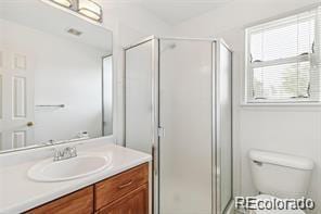 bathroom with vanity, an enclosed shower, and toilet