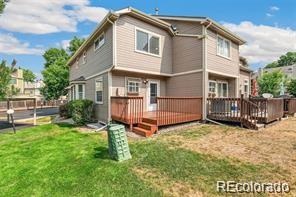 rear view of property featuring a yard and a deck