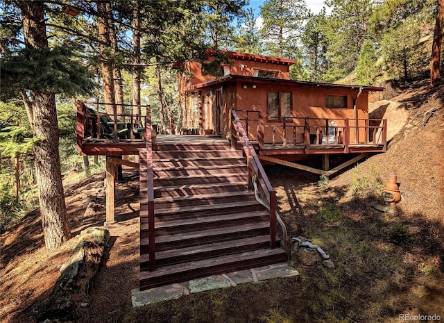 back of house featuring stairway and a wooden deck