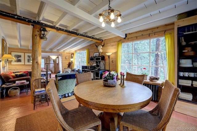 dining area with vaulted ceiling with beams, hardwood / wood-style floors, a notable chandelier, and wooden walls