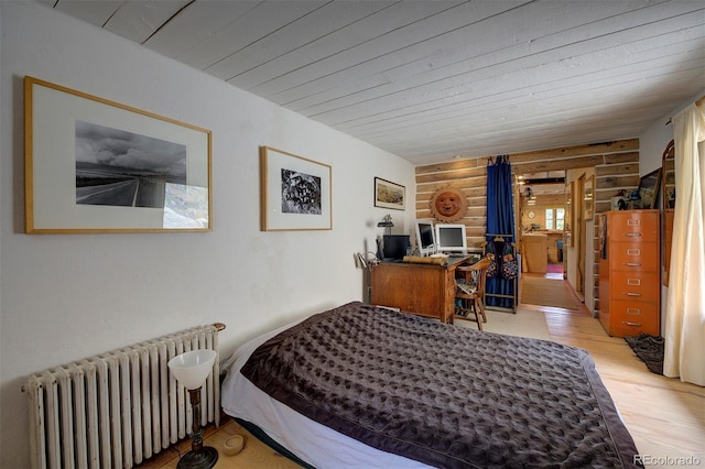 bedroom with rustic walls, wood finished floors, wooden ceiling, and radiator