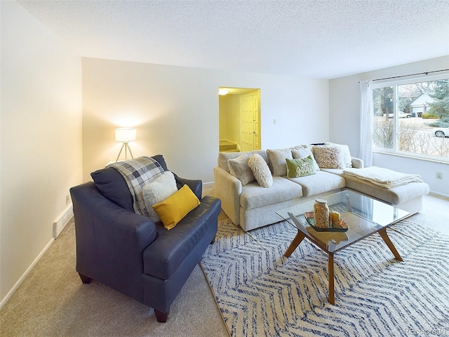 living area with carpet flooring, a textured ceiling, and baseboards
