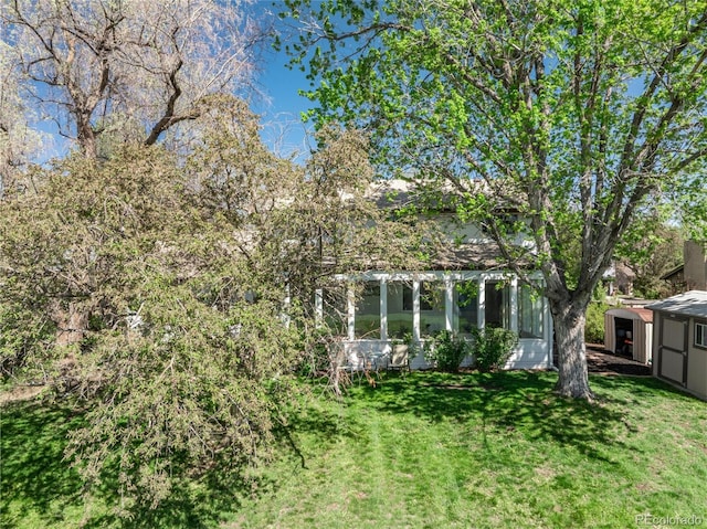 view of grassy yard with a sunroom