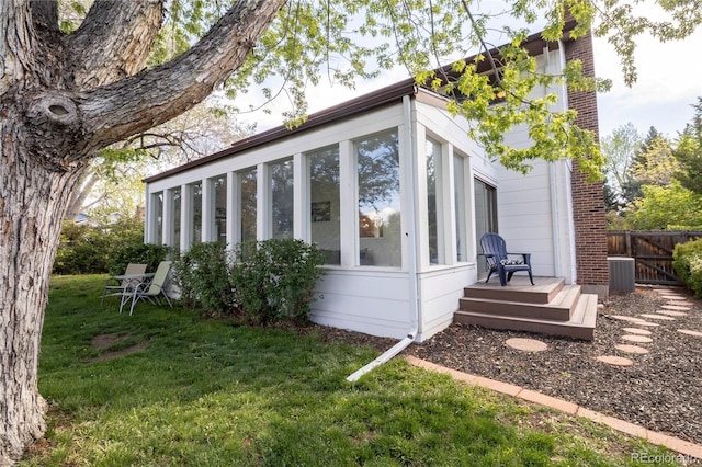 view of side of property featuring a sunroom and central air condition unit