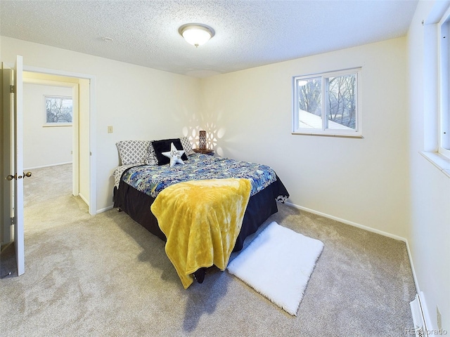 carpeted bedroom with a textured ceiling and baseboards