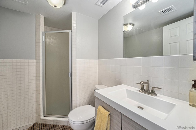 1020 15th St Unit 12C, Denver, CO 80202 - full bath featuring tile walls, a stall shower, vanity, tile patterned flooring, and wainscoting