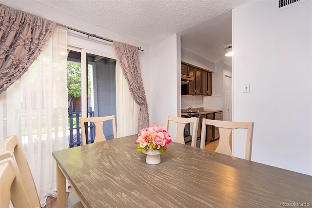 3341 S Monaco Pkwy Unit A, Denver, CO 80222 - dining room featuring a textured ceiling