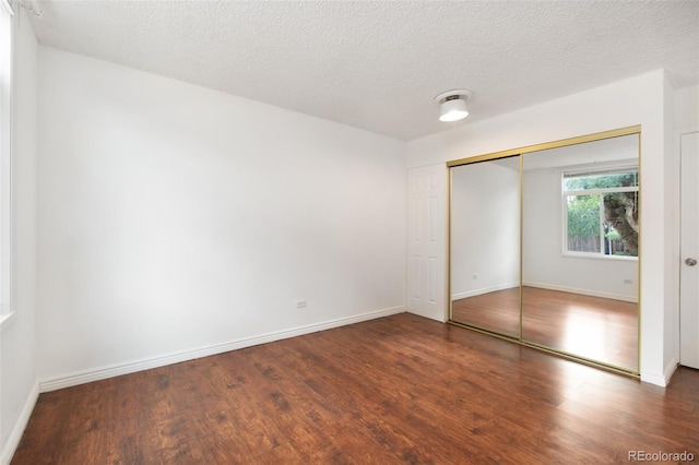 3341 S Monaco Pkwy Unit A, Denver, CO 80222 - unfurnished bedroom with wood finished floors, baseboards, a closet, and a textured ceiling