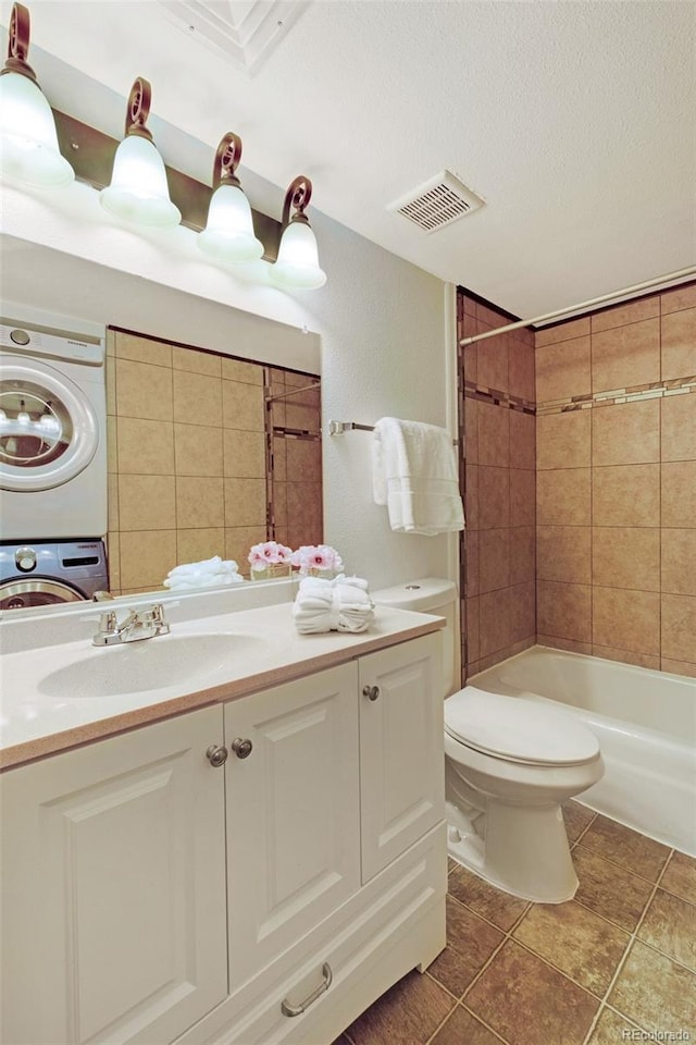 3341 S Monaco Pkwy Unit A, Denver, CO 80222 - full bath with estacked washer and dryer, vanity, toilet, a textured ceiling, and bathing tub / shower combination