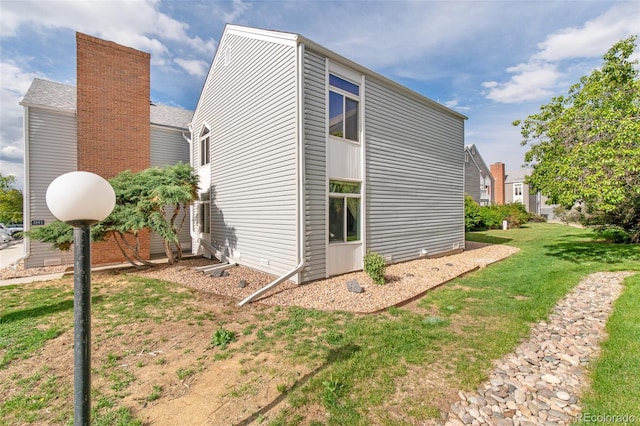 3341 S Monaco Pkwy Unit A, Denver, CO 80222 - view of side of property with a chimney and a lawn
