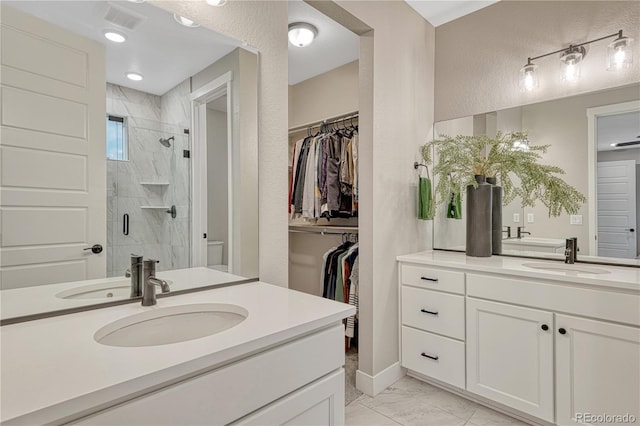 6366 N Emporia St, Denver, CO 80238 - bathroom with marble finish floors, two vanities, a shower stall, and a walk in closet