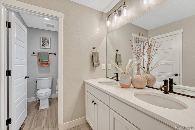 6366 N Emporia St, Denver, CO 80238 - bathroom with double vanity, wood finished floors, and a textured wall