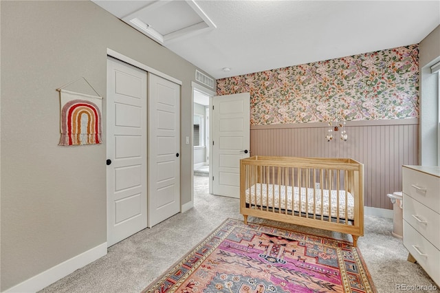 6366 N Emporia St, Denver, CO 80238 - bedroom with a wainscoted wall, attic access, a closet, light carpet, and wallpapered walls