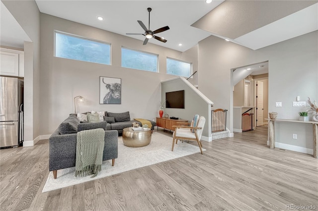 6366 N Emporia St, Denver, CO 80238 - living room with a ceiling fan, light wood finished floors, recessed lighting, stairway, and a high ceiling