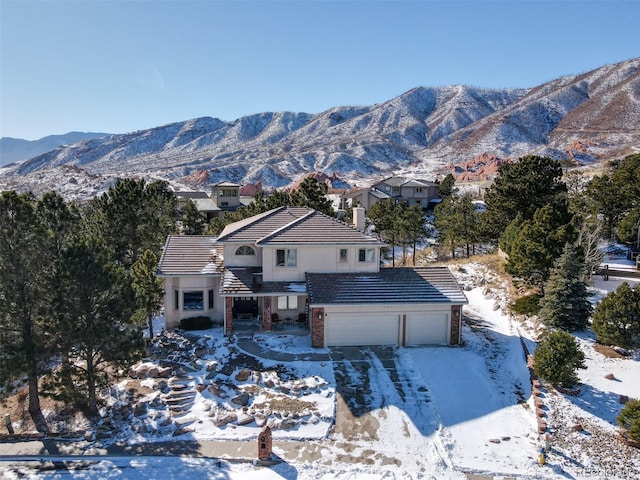 2770 Rossmere St, Colorado Springs, CO 80919 - view of front of home with a tiled roof, a mountain view, an attached garage, and driveway