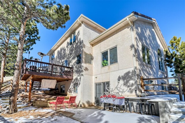 2770 Rossmere St, Colorado Springs, CO 80919 - snow covered property featuring a patio, a wooden deck, stairway, and stucco siding