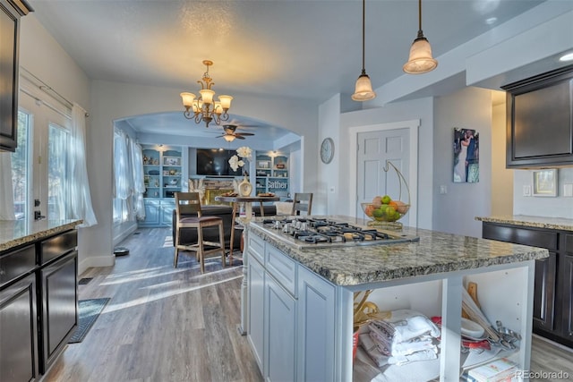2770 Rossmere St, Colorado Springs, CO 80919 - kitchen with arched walkways, stainless steel gas cooktop, a chandelier, and light wood finished floors