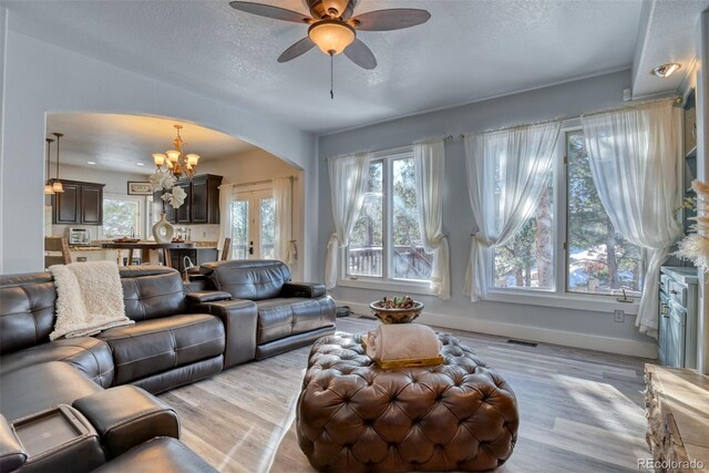2770 Rossmere St, Colorado Springs, CO 80919 - living area with arched walkways, a chandelier, a textured ceiling, light wood-type flooring, and ceiling fan