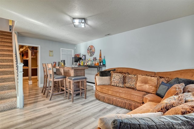 2770 Rossmere St, Colorado Springs, CO 80919 - living area featuring a dry bar, stairs, a textured ceiling, and wood finished floors