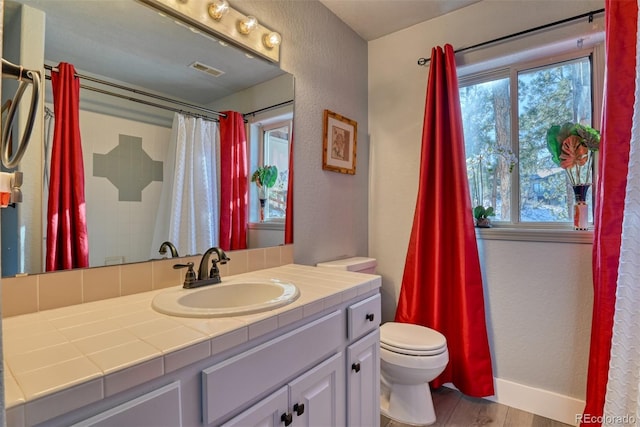 2770 Rossmere St, Colorado Springs, CO 80919 - bathroom featuring vanity, plenty of natural light, wood finished floors, a shower with curtain, and a textured wall
