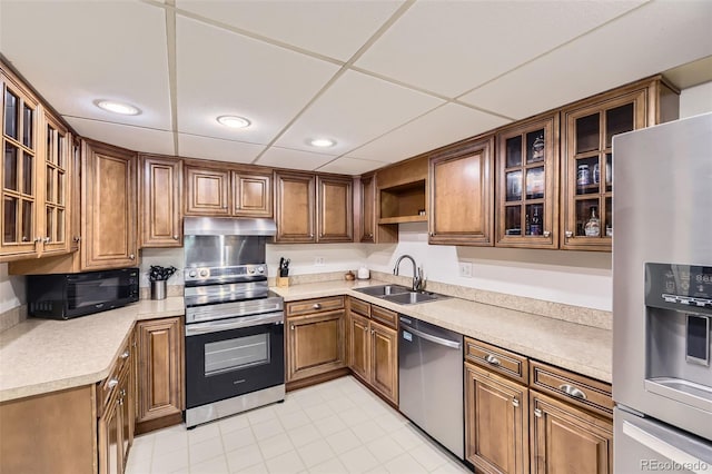 7020 E Girard Ave Unit 206, Denver, CO 80224 - kitchen with appliances with stainless steel finishes, under cabinet range hood, brown cabinetry, open shelves, and light countertops