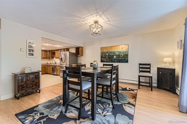 7020 E Girard Ave Unit 206, Denver, CO 80224 - dining room featuring a baseboard radiator, light wood-style floors, and a chandelier