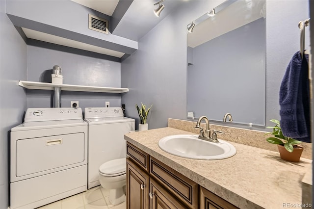 7020 E Girard Ave Unit 206, Denver, CO 80224 - bathroom featuring washing machine and clothes dryer, vanity, and tile patterned flooring