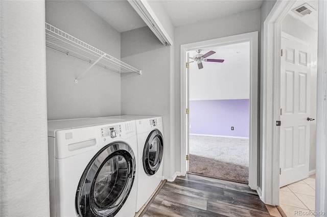 clothes washing area featuring ceiling fan, washer and clothes dryer, and wood-type flooring