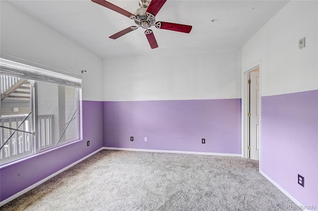 carpeted spare room featuring ceiling fan