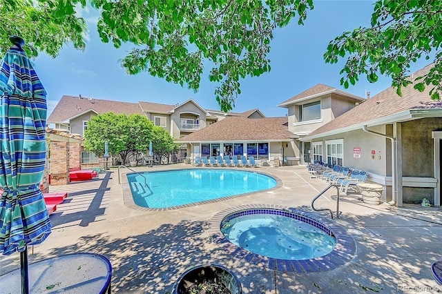 view of swimming pool featuring a patio area and a hot tub