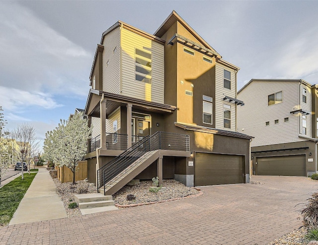 2564 Sweet Wind Ave, Castle Rock, CO 80109 - view of front of property with an attached garage, stucco siding, decorative driveway, and stairway