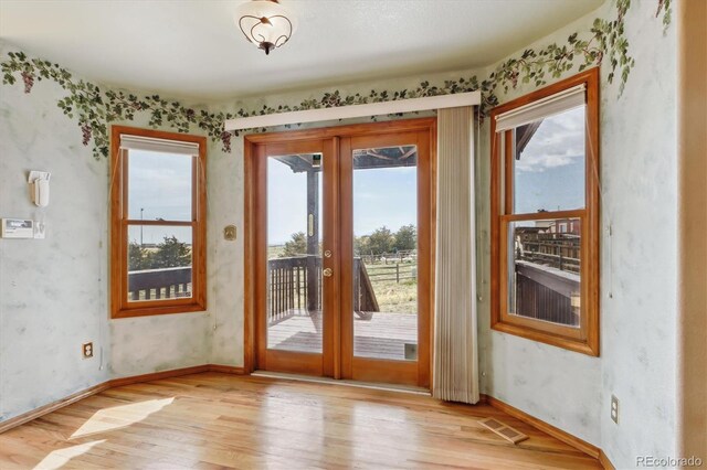 9920 Glenellen Dr, Peyton, CO 80831 - entryway featuring visible vents, baseboards, light wood-type flooring, wallpapered walls, and french doors