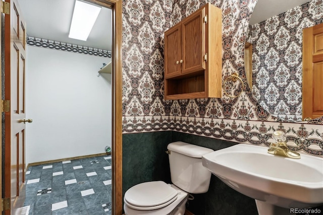 9920 Glenellen Dr, Peyton, CO 80831 - half bath featuring visible vents, toilet, a sink, wallpapered walls, and baseboards