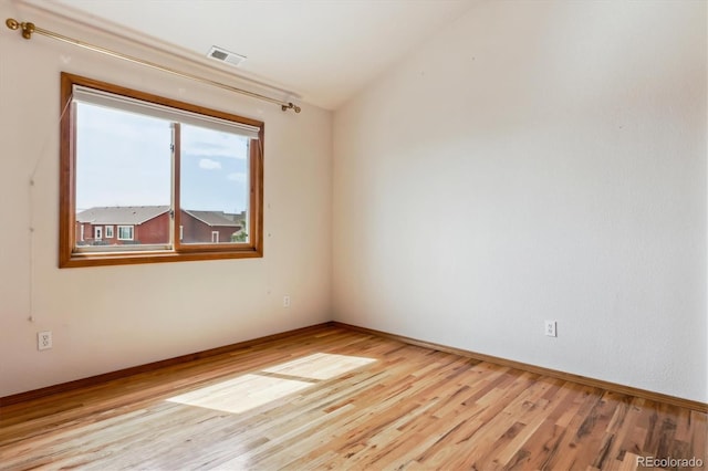 9920 Glenellen Dr, Peyton, CO 80831 - empty room featuring visible vents, baseboards, vaulted ceiling, and wood finished floors