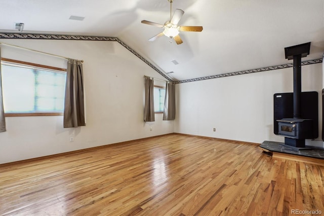 9920 Glenellen Dr, Peyton, CO 80831 - unfurnished living room featuring ceiling fan, a wood stove, light wood-type flooring, lofted ceiling, and baseboards