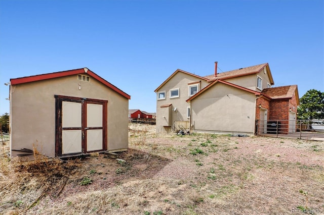 9920 Glenellen Dr, Peyton, CO 80831 - rear view of property with a storage shed, stucco siding, an outdoor structure, and fence